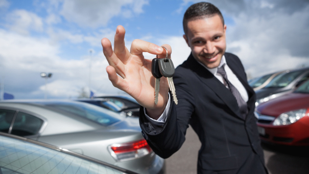 Happy dealer holding car keys